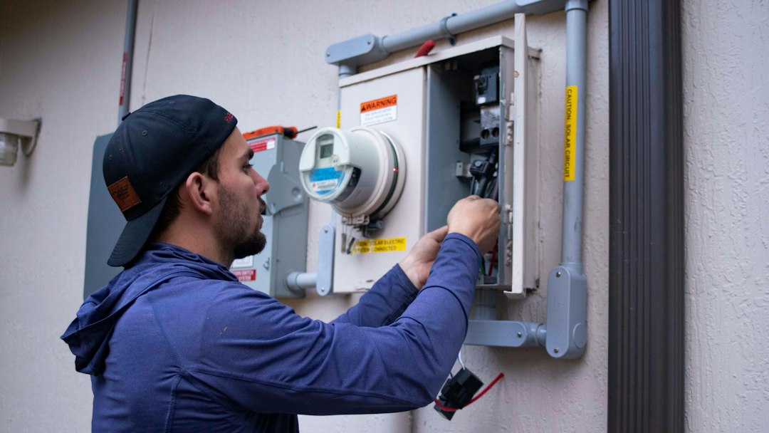 Technician performing electrical diagnostics during heat-pump service